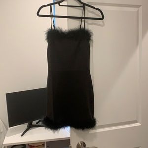 Black mini dress with faux fur trim on top and bottom. #part #beginningboutique